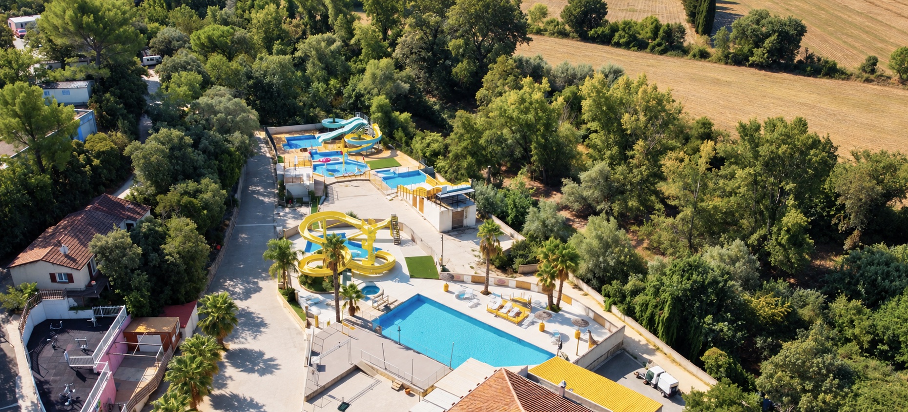 Vue aérienne des piscines et des toboggans entourés de verdure